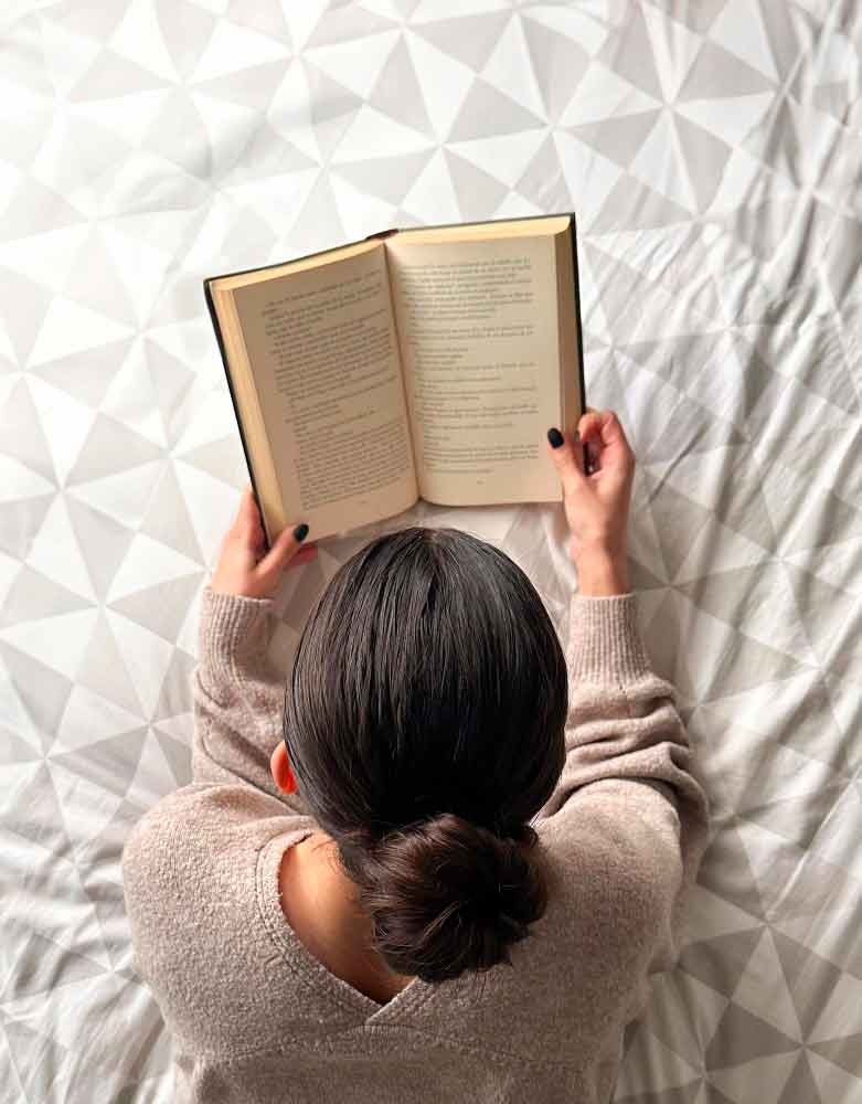 une femme de dos lit un livre