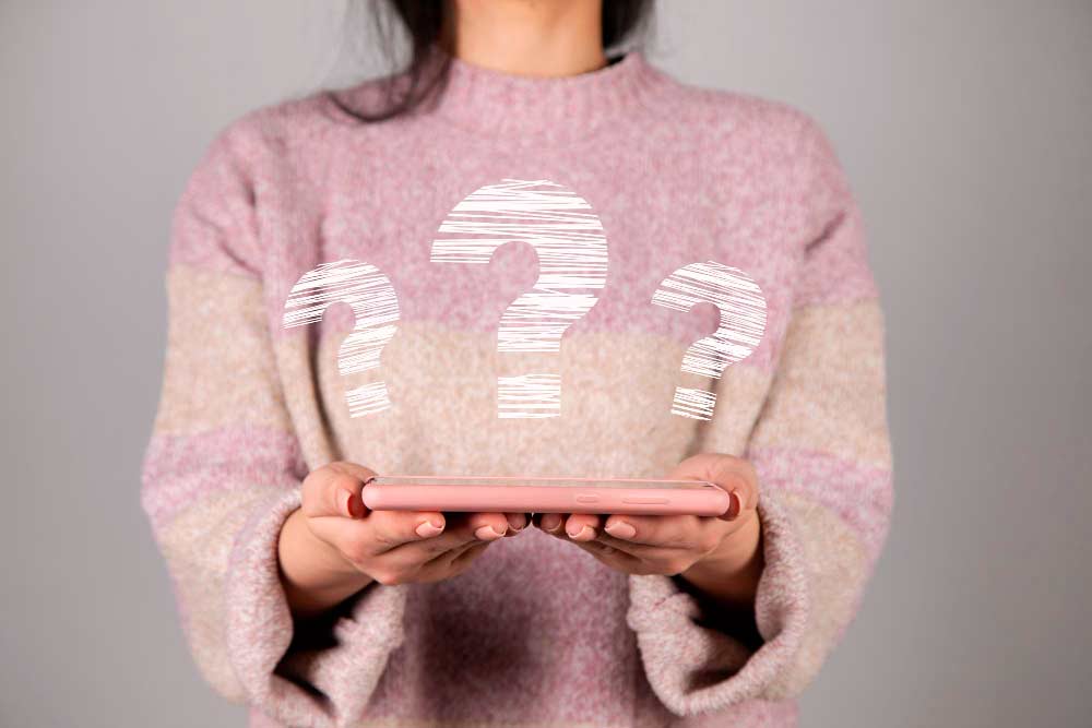 femme tenant une tablette avec des points d’interrogation